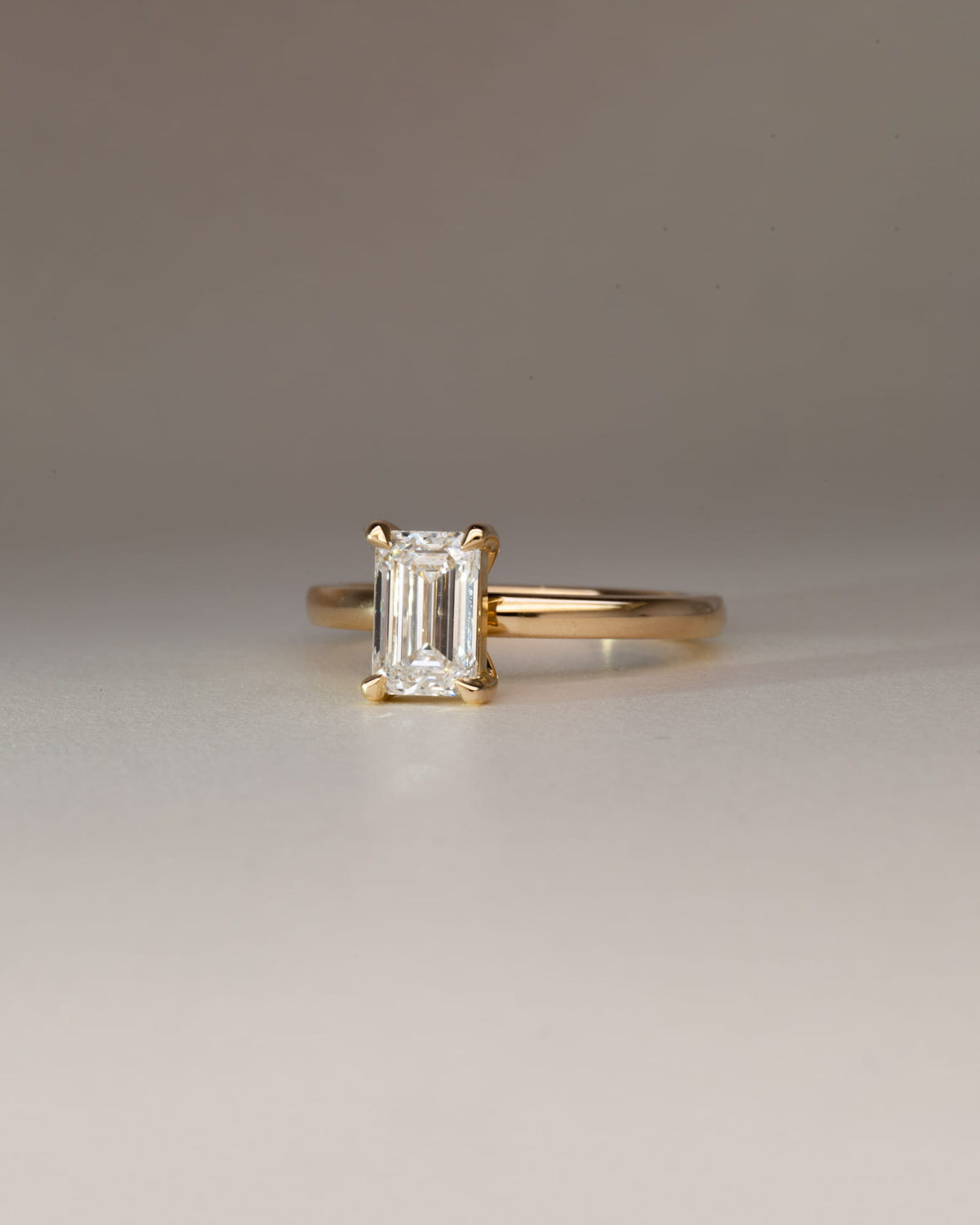 Bespoke emerald cut diamond solitaire engagement ring in 18K yellow gold — 1.29ct natural diamond, handcrafted by Benjamin Rose Melbourne