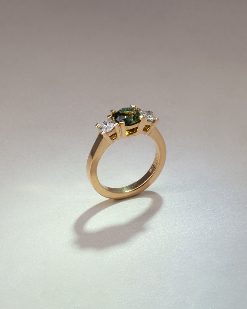 Bespoke square claw trilogy engagement ring in 18K yellow gold with 1.23ct round Australian sapphire and round brilliant lab diamond side stones — handcrafted by Benjamin Rose Melbourne