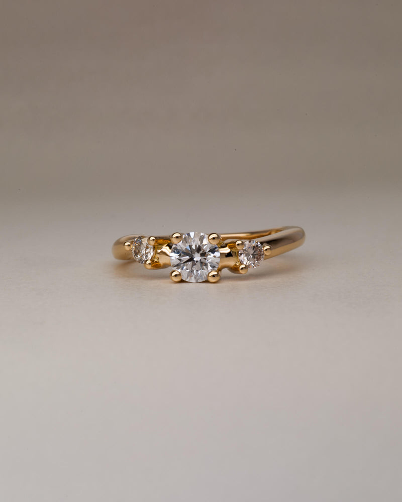 Bespoke wavy trilogy engagement ring in 18K yellow gold with 0.46ct round brilliant natural diamond and champagne diamond side stones — handcrafted by Benjamin Rose Melbourne