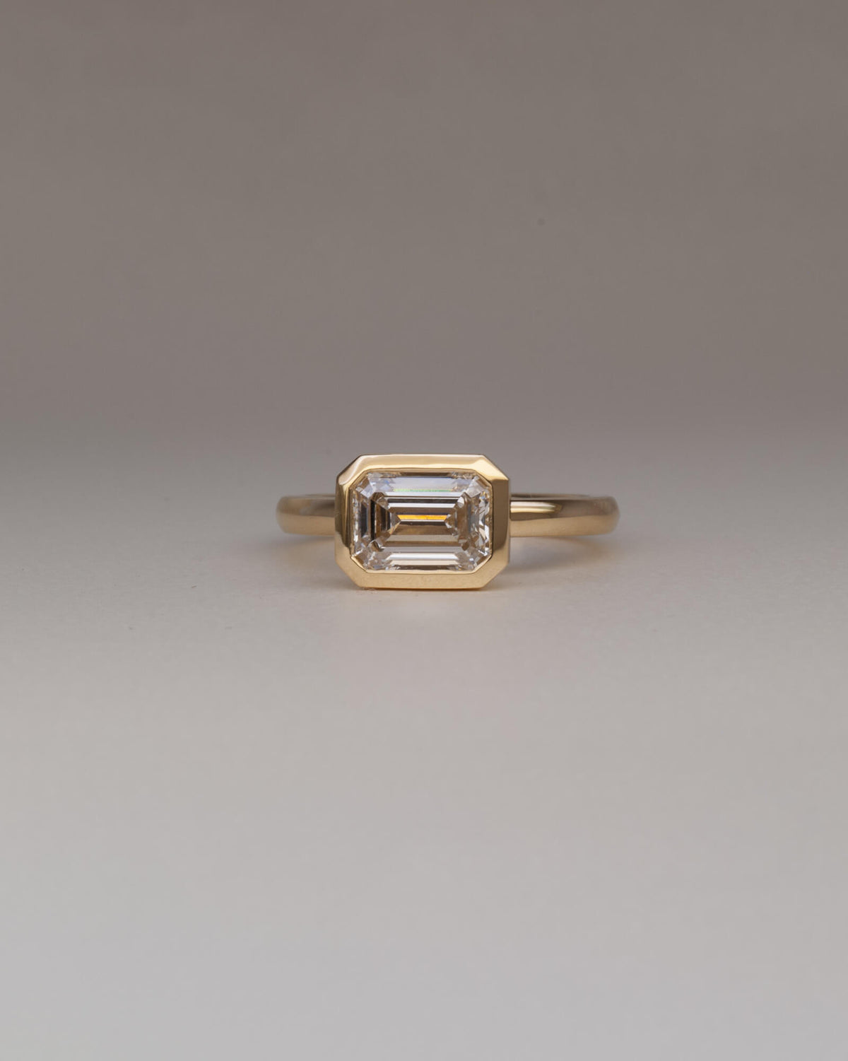 Bespoke Bella east west bezel solitaire engagement ring in 18K yellow gold with 1.55ct emerald cut lab grown diamond — handcrafted by Benjamin Rose Melbourne