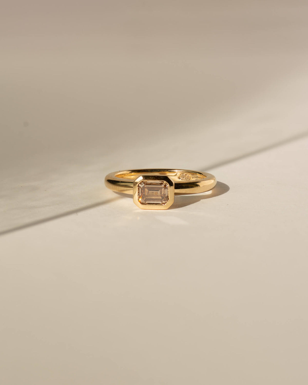 Bespoke Bella emerald cut bezel solitaire engagement ring in 18K yellow gold with champagne diamond — handcrafted by Benjamin Rose Melbourne