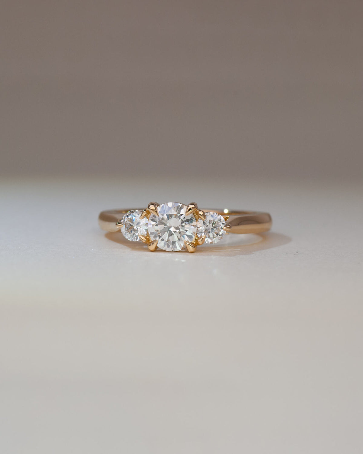 Bespoke Bianca trilogy engagement ring in 18K yellow gold with 0.56ct round brilliant lab diamond and lab diamond side stones — handcrafted by Benjamin Rose Melbourne
