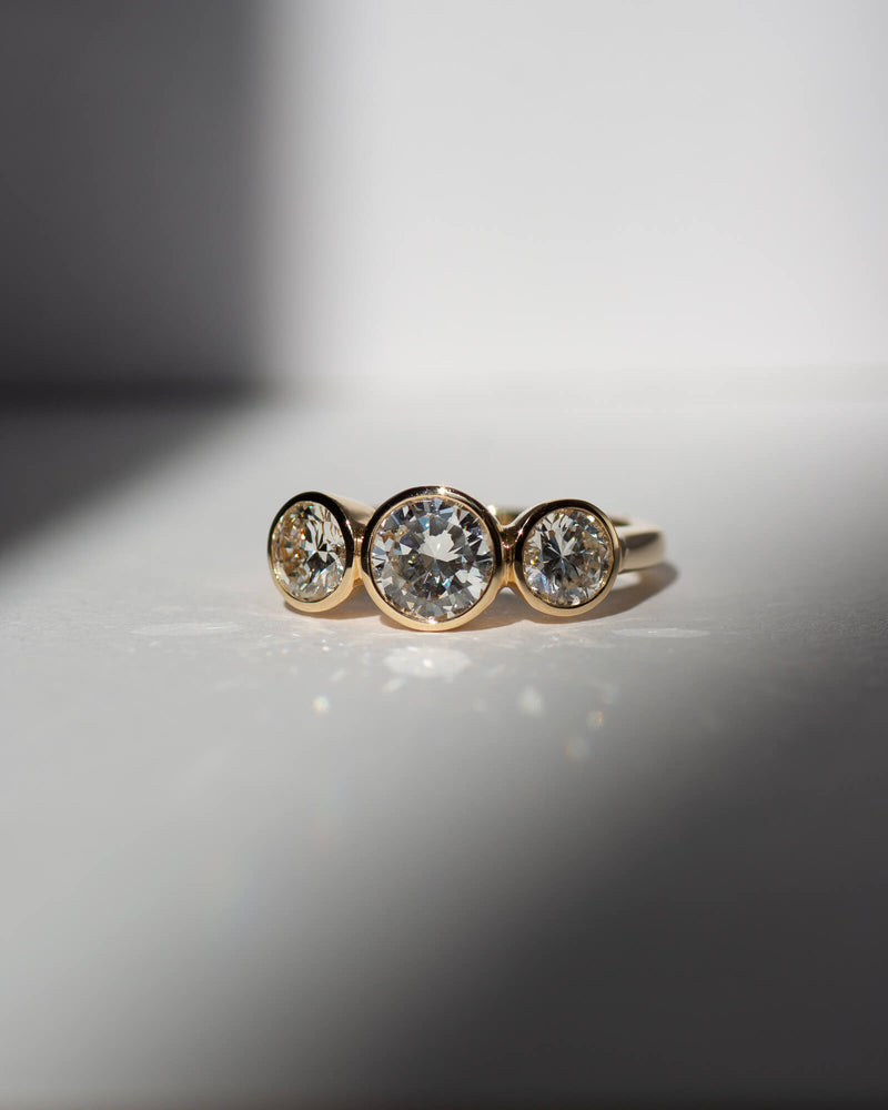 Bespoke three stone bezel trilogy engagement ring in 18K yellow gold with natural heirloom diamonds — handcrafted by Benjamin Rose Melbourne