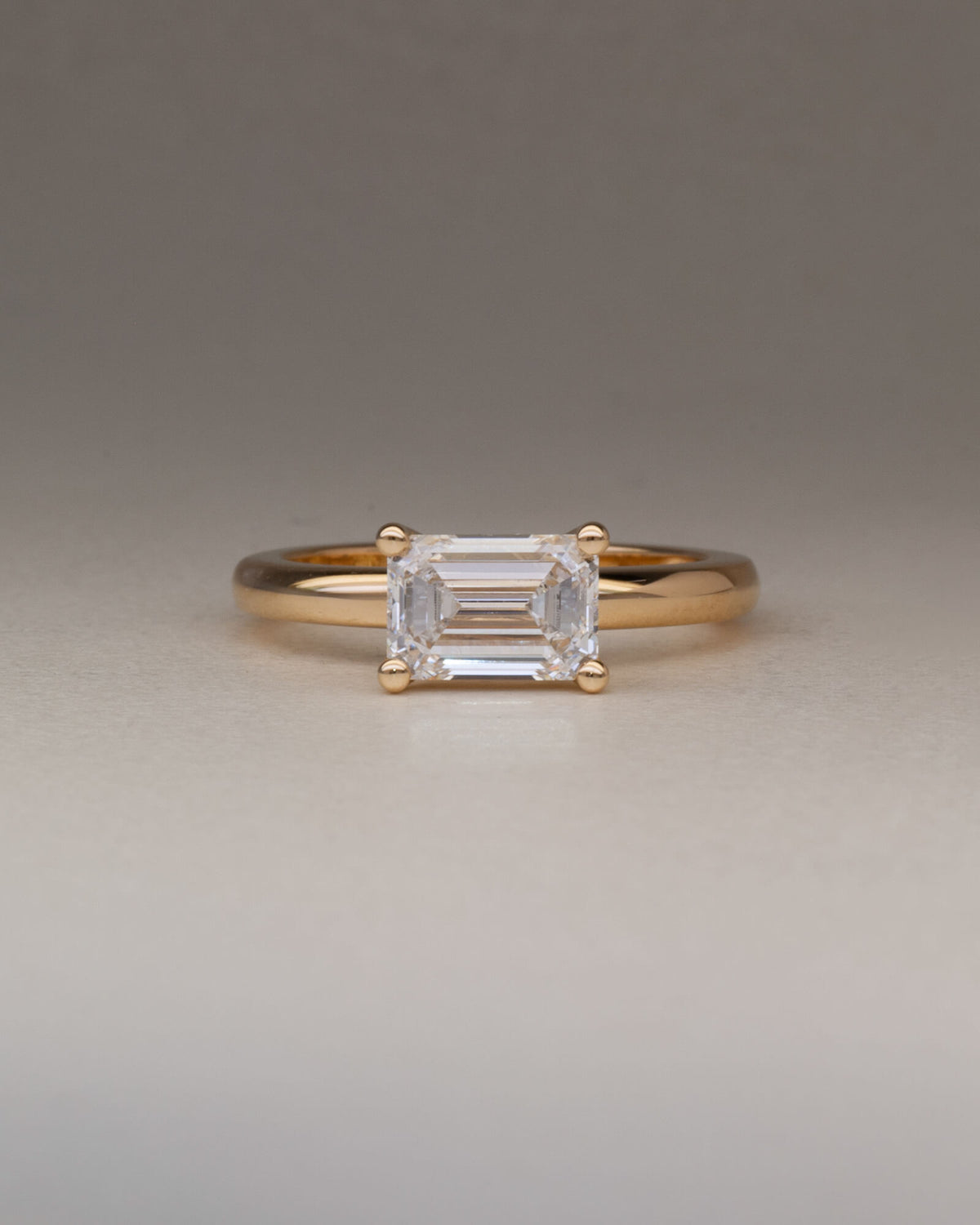 Bespoke east west four claw emerald cut solitaire engagement ring in 18K yellow gold with 1.52ct lab grown diamond — handcrafted by Benjamin Rose Melbourne