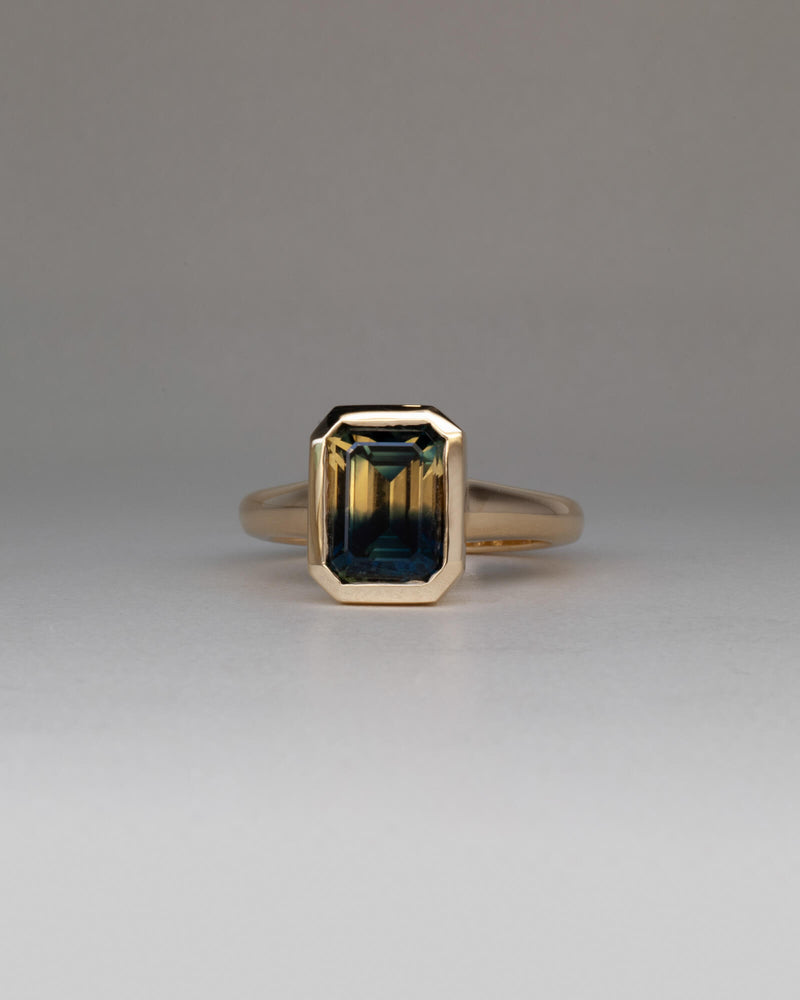 Bespoke Maia emerald cut bezel solitaire engagement ring in 18K yellow gold with 3.37ct Australian parti sapphire — handcrafted by Benjamin Rose Melbourne