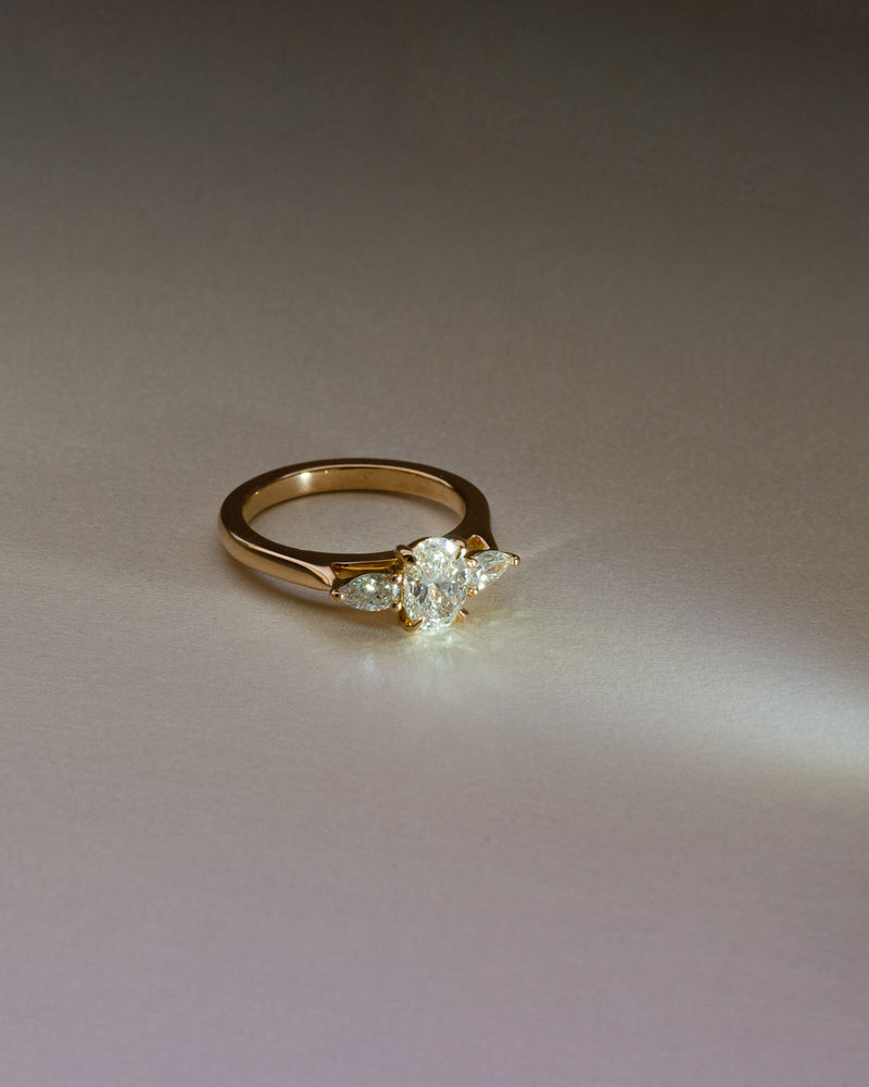 Bespoke oval and pear trilogy engagement ring in 18K yellow gold with 0.81ct natural oval diamond and pear cut diamond side stones — handcrafted by Benjamin Rose Melbourne