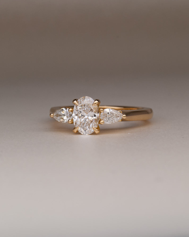 Bespoke oval and pear trilogy engagement ring in 18K yellow gold with 0.81ct natural oval diamond and pear cut diamond side stones — handcrafted by Benjamin Rose Melbourne