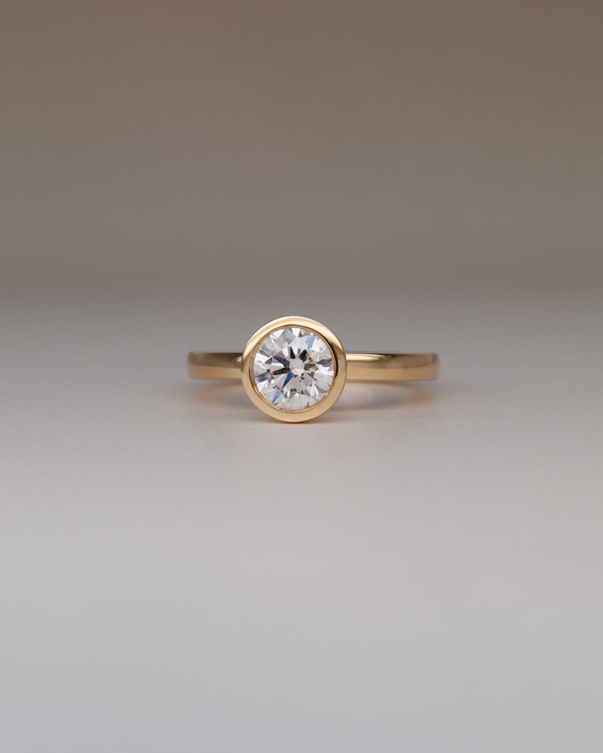 Bespoke round bezel solitaire engagement ring in 18K yellow gold with 1.01ct natural diamond — handcrafted by Benjamin Rose Melbourne
