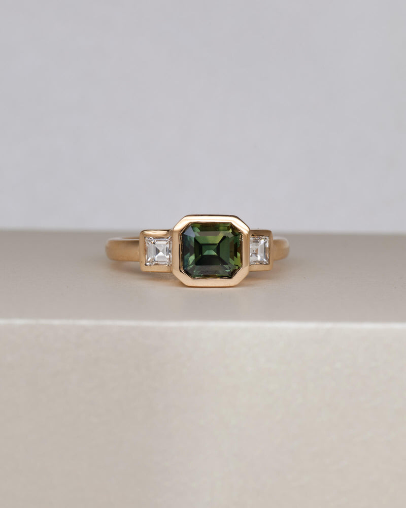 Bespoke sapphire trilogy engagement ring in 18K yellow gold with 1.48ct Australian sapphire and carré cut diamond side stones — handcrafted by Benjamin Rose Melbourne