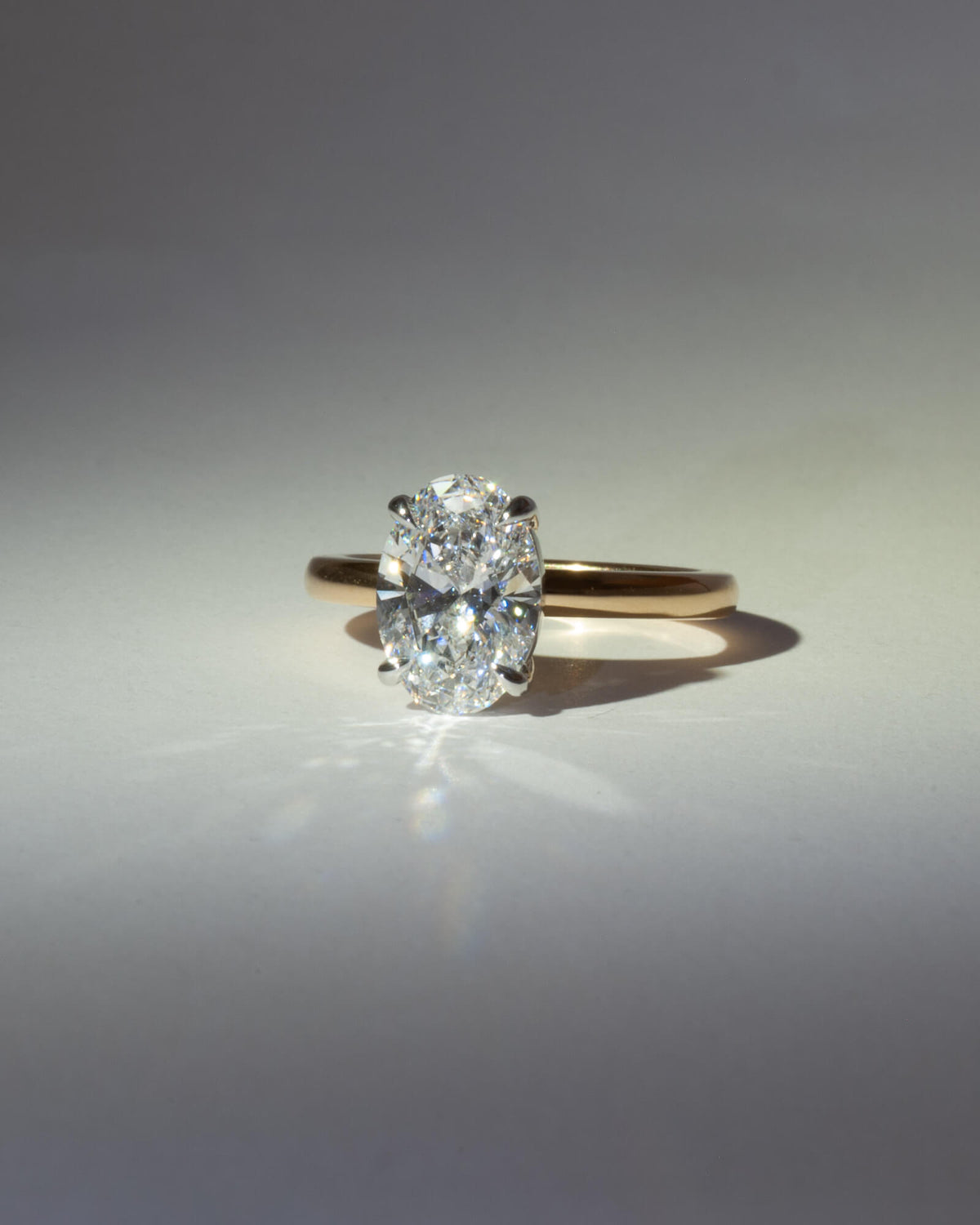 Bespoke oval solitaire engagement ring with 18K yellow gold band and white gold setting — 2.26ct lab grown diamond, handcrafted by Benjamin Rose Melbourne